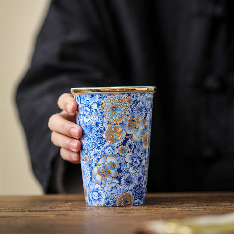 Ru-Crackles-Ceramic-Mug-with-Golden-Detailing-of-Blue-Floral-Patterns-in-hand