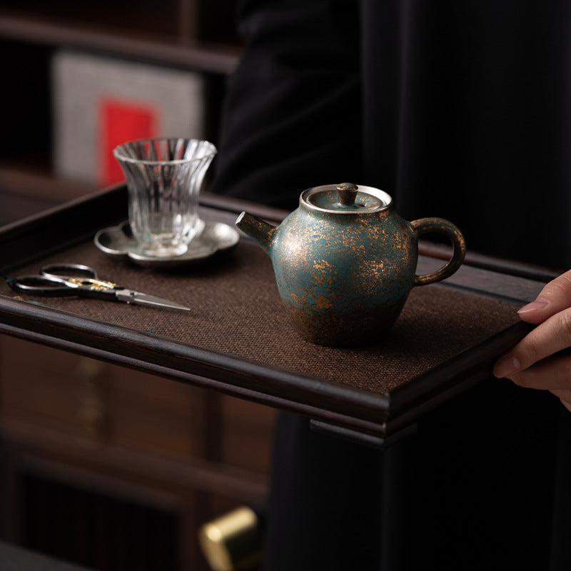 Golden-Azur Aureated Kiln Trans Compact Teapot displaying on a tea tray with a glass teacup and a pair of scissors