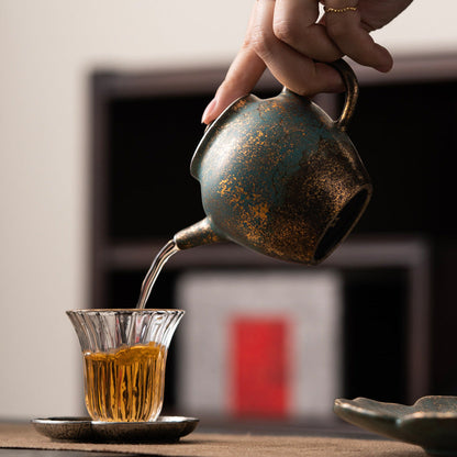 Golden-Azur Aureated Kiln Trans Compact Teapot pouring out tea into a small glass 