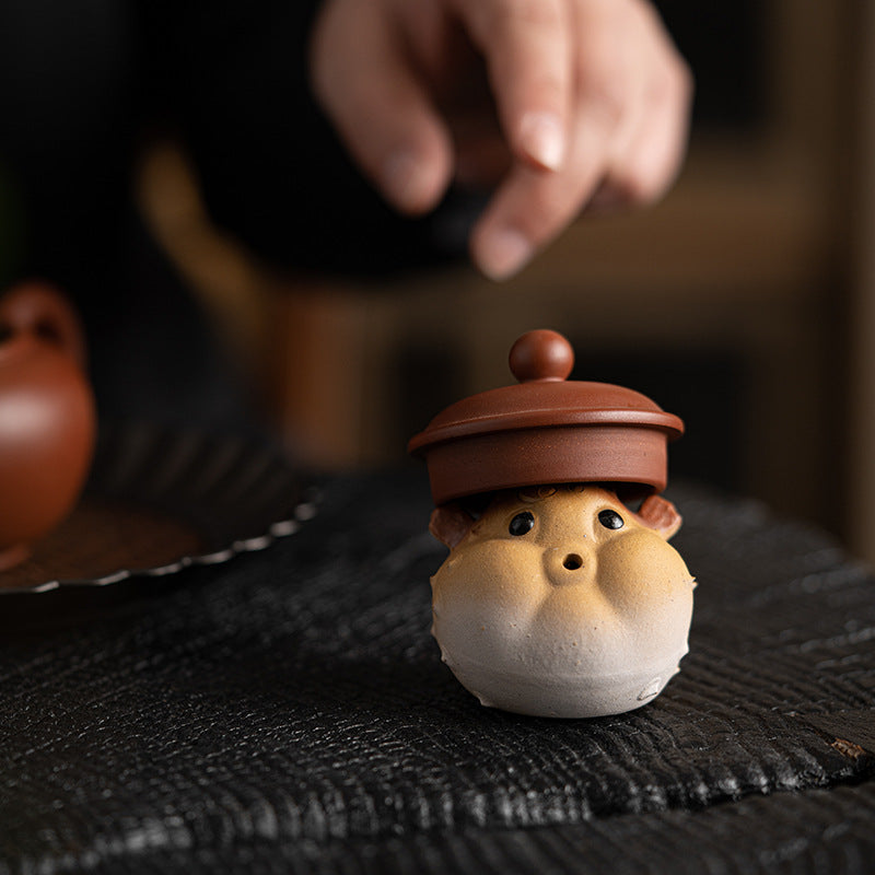 Purple-Sand Mud Puffer Fish Incense Holder holding a teapot lid